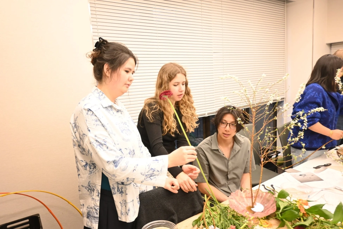 Young participants in a flower arrangement workshop, intently working with colorful flowers.