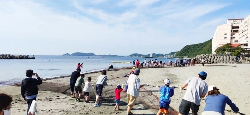 Family participating in beach seine fishing