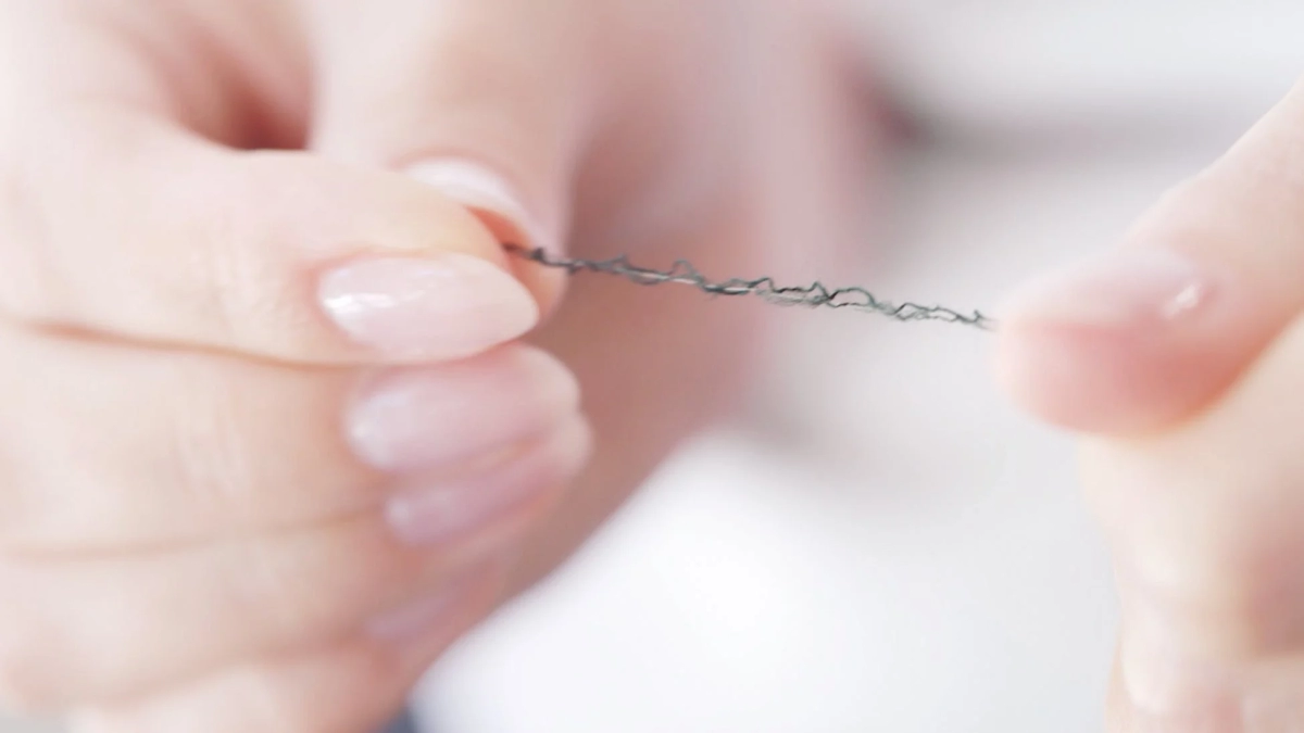 Fingers holding yarn