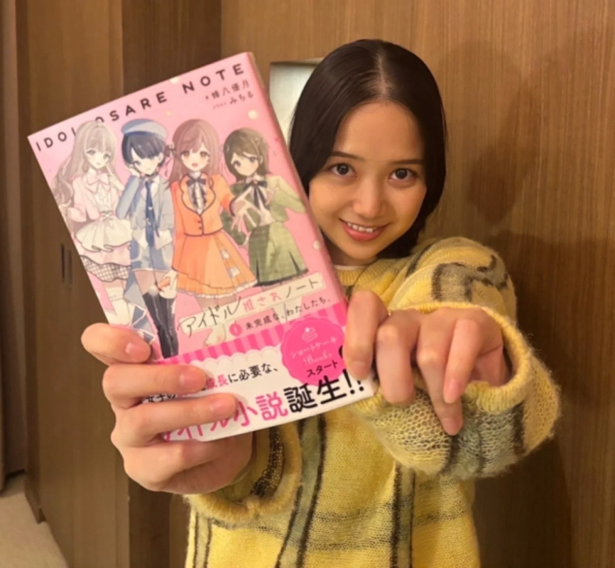 Author Yuzuki Hachiya holding the book Idol Osare Note