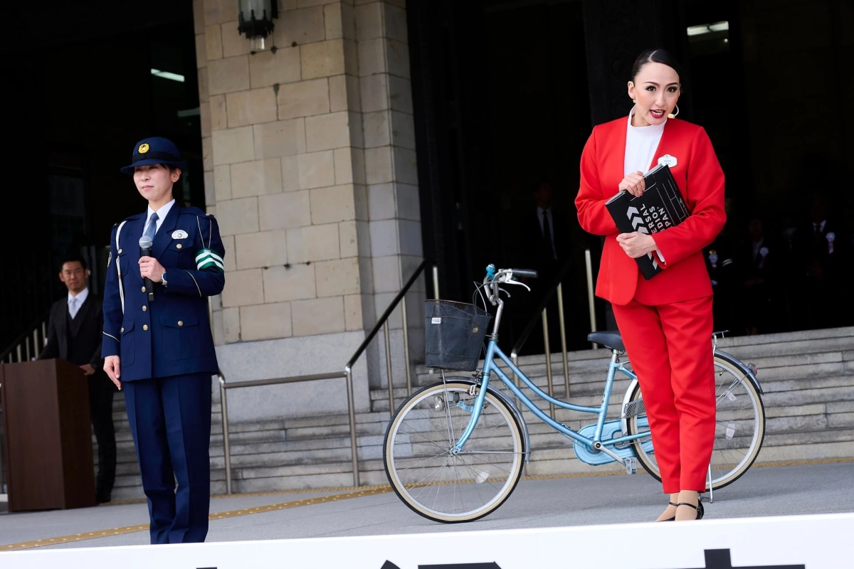 Female police officer, woman in red suit with clapboard, bicycle