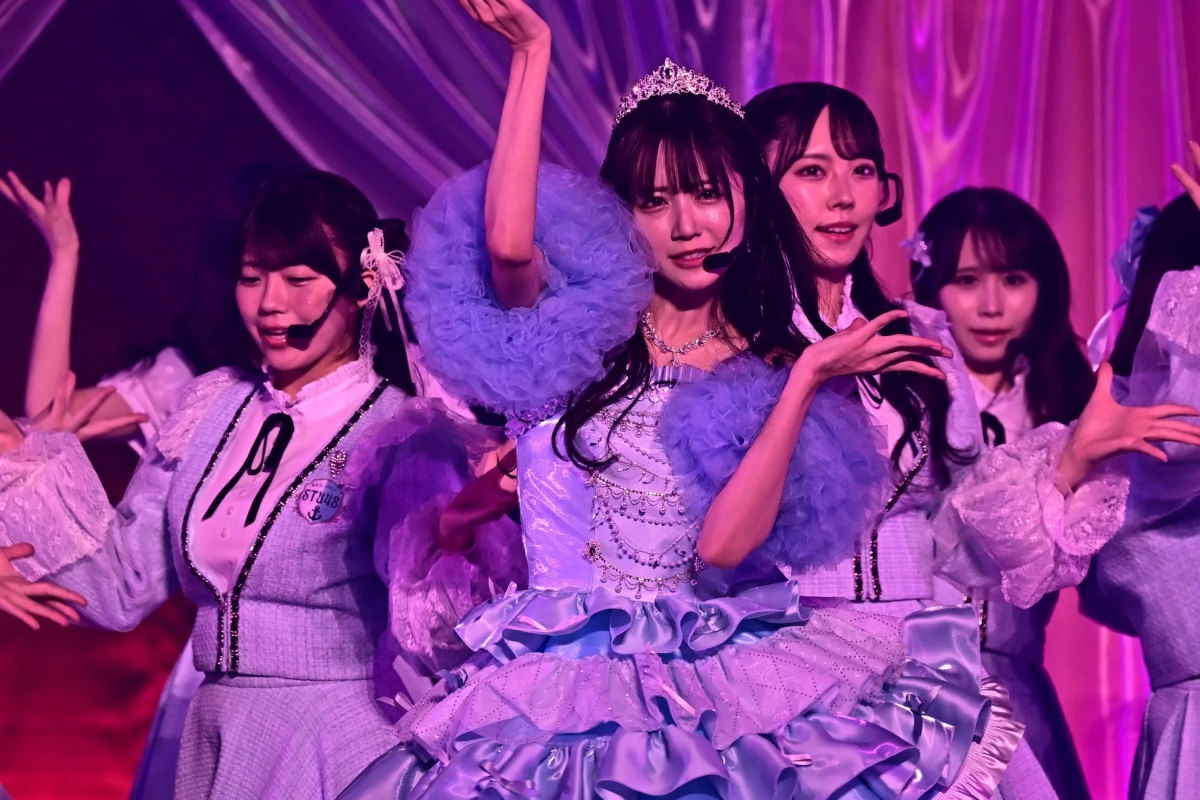 STU48 members performing on stage in elaborate purple and white costumes