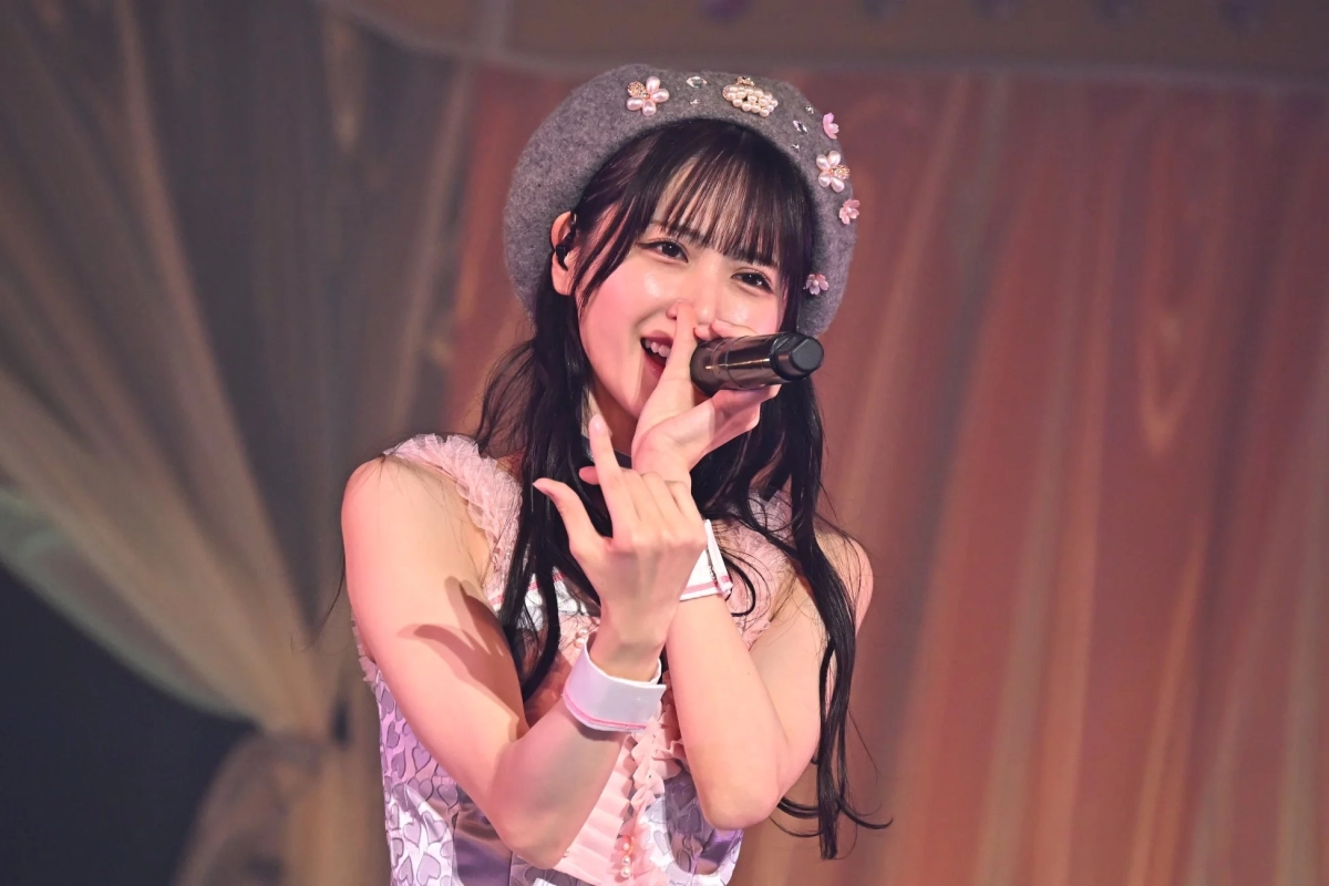 Nakamura Mai singing into a microphone with a floral beret