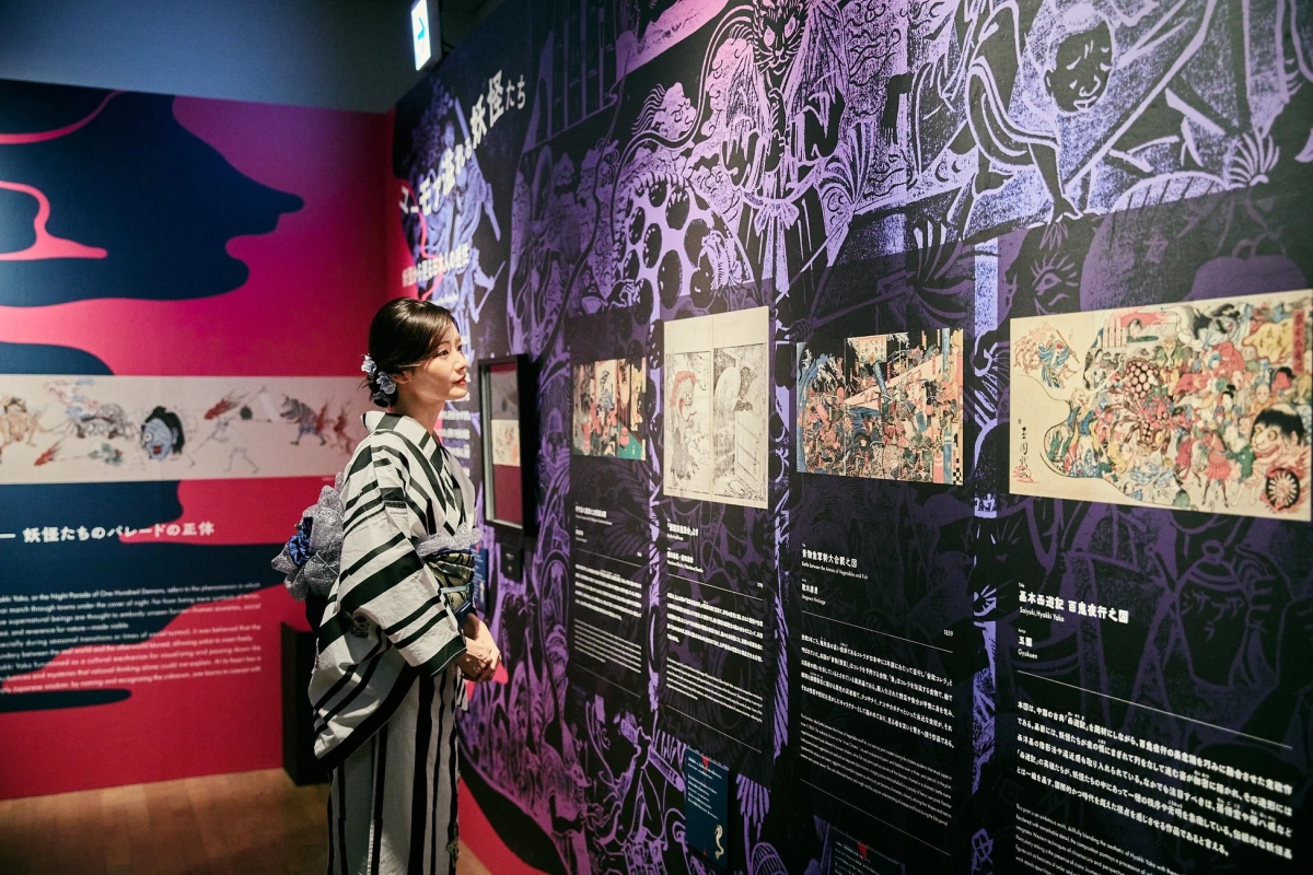 Woman in kimono viewing an art explanation display
