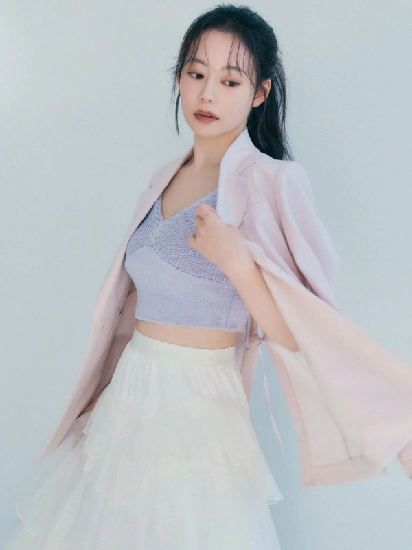 Model in pale pink jacket and white skirt