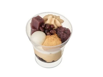 A close-up of the Kinako to Anko no Wa Parfait, showcasing layers of red bean paste, kinako, mochi, and cream in a clear cup.