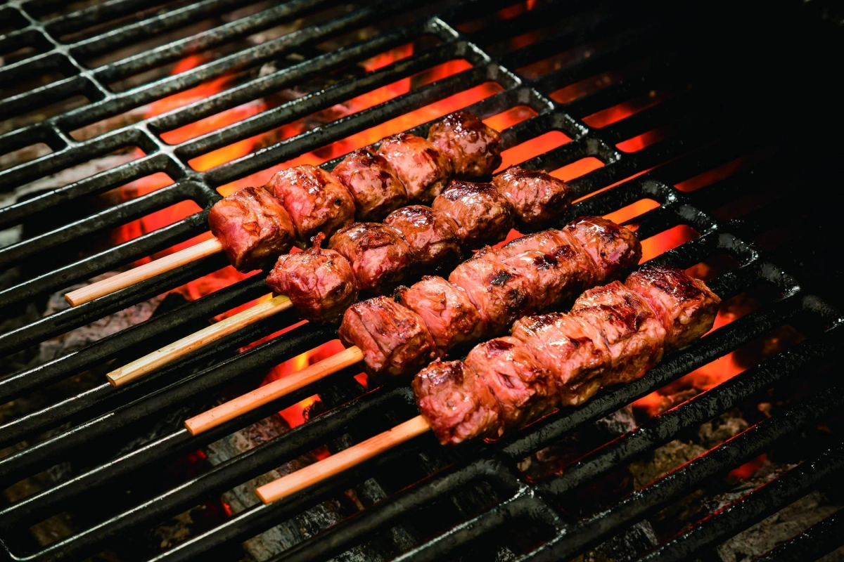 Grilled meat skewers sizzling over hot coals, promising a delicious and juicy experience.