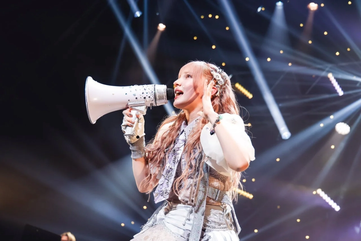 Noel Hayase on stage with a megaphone