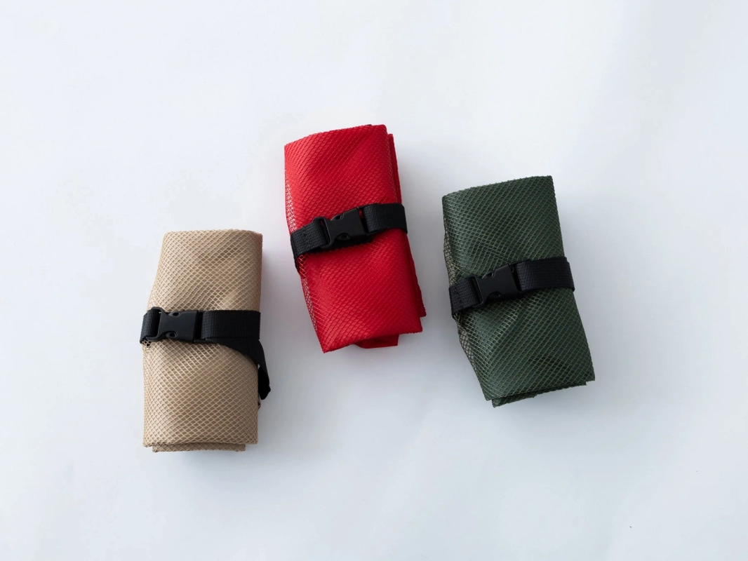 Rolled-up Travel Shoppers in beige, red, and green