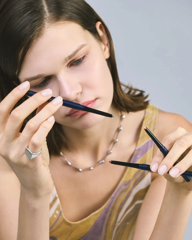 Woman holding multiple makeup pencils